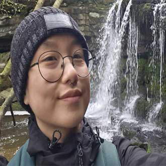 Profile of a male student standing beside a waterfall